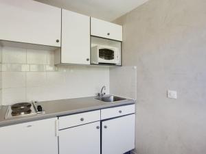 a white kitchen with a sink and a microwave at Studio Palafour - Le Lac-3 by Interhome in Tignes