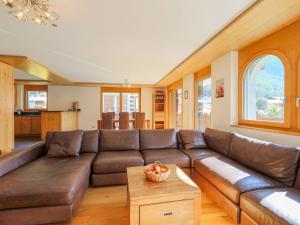a living room with a brown leather couch at Apartment Whymper by Interhome in Zermatt