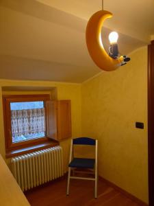 a yellow room with a blue chair and a banana light at Casa Sigiu - La Vetta in Terminillo