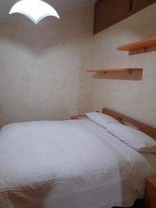 sypialnia z białym łóżkiem i oknem w obiekcie Casa Sigiu - La Vetta w mieście Terminillo