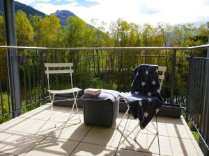 two chairs and a table on a balcony with mountains at Apartment Chesa San Bastiaun B4 by Interhome in Samedan