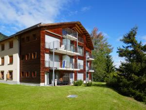 an apartment building with a lawn in front of it at Apartment Chesa San Bastiaun B4 by Interhome in Samedan