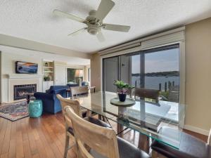 a dining room with a glass table and a ceiling fan at 101 Edgewater Inn in Charlevoix