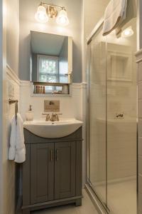 uma casa de banho com um lavatório e um chuveiro em Homestead Inn em New Milford