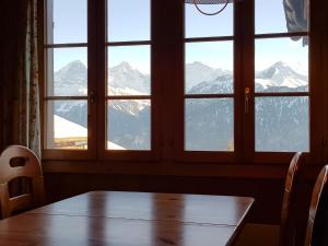 a dining room table with a view of mountains at Apartment Chalet Burgfeld by Interhome in Beatenberg