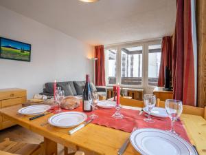 una mesa de madera con platos y copas de vino. en Apartment Le Prariond - Val Claret-11 by Interhome, en Tignes