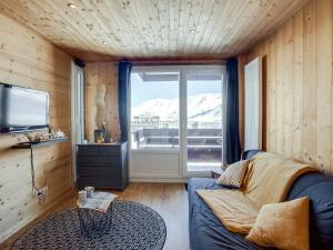 a living room with a couch and a large window at Studio Le Curling A - Val Claret-21 by Interhome in Tignes
