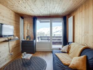 a living room with a couch and a large window at Studio Le Curling A-21 by Interhome in Tignes