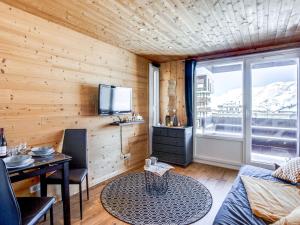 a room with a wooden wall with a tv and a table at Studio Le Curling A - Val Claret-21 by Interhome in Tignes