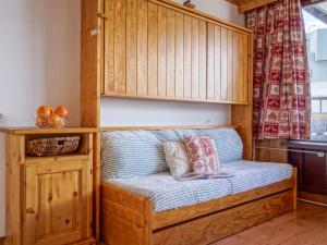 a bed in a room with a wooden cabinet at Studio Les Genepis-3 by Interhome in Tignes