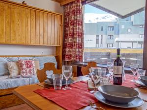 a table with a bottle of wine and glasses on it at Studio Les Genepis-3 by Interhome in Tignes