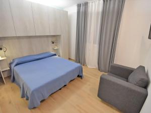 a bedroom with a bed and a couch and a chair at Villa Cà Riviera Bosco Piccolo by Interhome in Malcontento