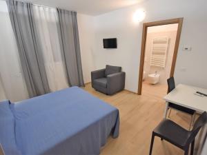 a bedroom with a bed and a chair and a desk at Villa Cà Riviera Bosco Piccolo by Interhome in Malcontento