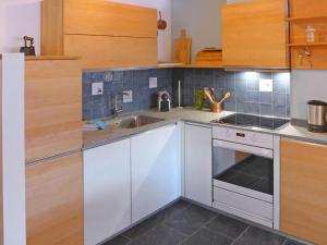 - une cuisine avec des placards blancs et un évier dans l'établissement Apartment Fis by Interhome, à Zermatt