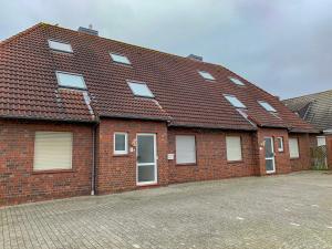 a red brick house with a brown roof at Apartment Sanddüne by Interhome in Norddeich +37 photos