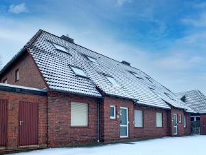 a red brick house with snow on the roof at Apartment Sanddüne by Interhome in Norddeich