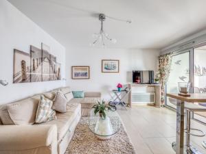 a living room with a couch and a table at Apartment Le Newport-2 by Interhome in Fréjus