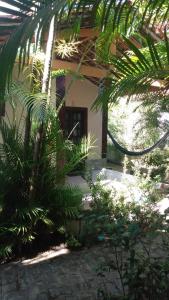 マリア・ファリーニャにあるOkakoaras Hotelのヤシの木が目の前にある家