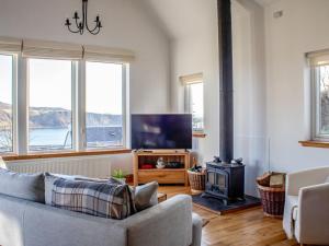 a living room with a couch and a stove at Holiday Home Bay View by Interhome in Uig