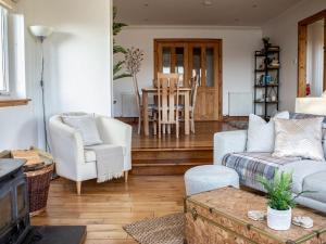 a living room with a couch and chairs and a table at Holiday Home Bay View by Interhome in Uig