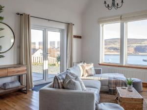 a living room with a couch and large windows at Holiday Home Bay View by Interhome in Uig