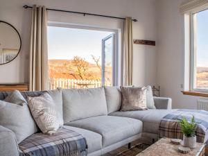 a living room with a couch and a large window at Holiday Home Bay View by Interhome in Uig