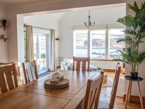 a dining room with a table and chairs with a view at Holiday Home Bay View by Interhome in Uig