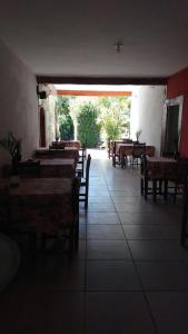 un restaurante con mesas y sillas y una gran ventana en Okakoaras Hotel en Maria Farinha