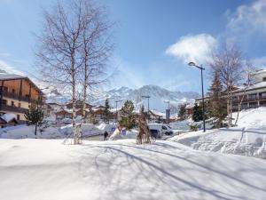een straat bedekt met sneeuw met bergen op de achtergrond bij Apartment Les Grandes Balmes I et II - Le Lac-10 by Interhome in Tignes