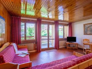 een woonkamer met een paarse bank en ramen bij Apartment Les Grandes Balmes I et II - Le Lac-10 by Interhome in Tignes