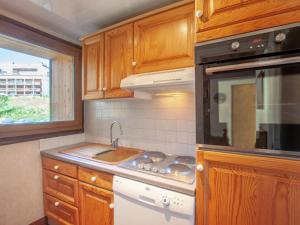 a kitchen with a stove top oven next to a window at Apartment Les Grandes Balmes I et II - Le Lac-10 by Interhome in Tignes