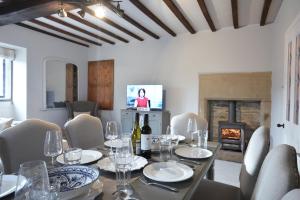 a dining room with a table and a fireplace at Postman's Knock in Hassop