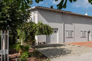 a white house with a bench in front of it at Le Makè bed & breakfast in Campi Bisenzio