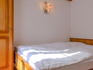 een slaapkamer met een wit bed met een licht aan de muur bij Apartment Pia-2 by Interhome in Zermatt +18 foto's