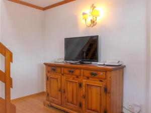 a tv sitting on top of a wooden dresser at Apartment Casa Pia-2 by Interhome in Zermatt