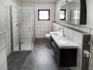 a bathroom with a sink and a shower and a toilet at Apartment Am Hohen Bogen-35 by Interhome in Arrach