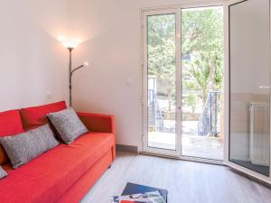 a living room with a red couch and a large window at Apartment Les Mâts-1 by Interhome in Saint-Palais-sur-Mer