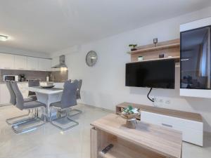 a living room with a table and a television on a wall at Apartment Meden by Interhome in Galižana