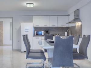 kuchnia z białym stołem i krzesłami w pokoju w obiekcie Apartment Meden by Interhome w mieście Galižana +25 zdjęć