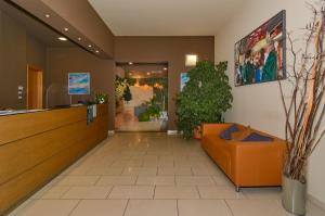 a lobby with an orange couch in a building at Residence San Rossore in Pisa +48 photos