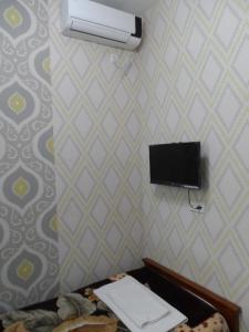 a room with a bed with a air conditioner on the wall at Jahongir B&B Tashkent in Tashkent