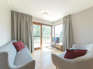 a living room with a couch and chairs and a television at Apartment Residentie Cannes 208 by Interhome in Bredene