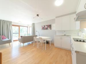 a kitchen and living room with a table and chairs at Apartment Cannes 208 with balcony by Interhome in Bredene