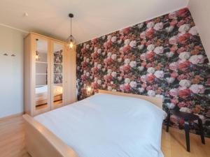 a bedroom with a white bed and a floral wall at Apartment Residentie Cannes 208 by Interhome in Bredene