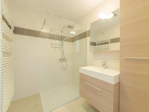 een witte badkamer met een douche en een wastafel bij Apartment Residentie Seaside by Interhome in Bredene