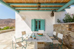 une table et des chaises sur une terrasse avec une porte verte dans l'établissement Magganari View Village, à Manganari