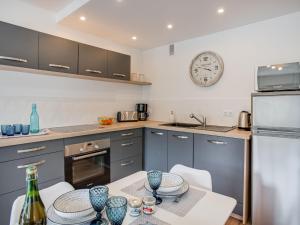キブロンにあるApartment Les Gemeaux-6 by Interhomeのテーブルと壁に時計があるキッチン