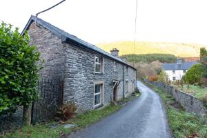 una vieja casa de piedra en un camino de tierra en Country Cottage In The Dyfi Valley, en Corris
