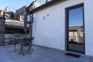 patio ze stołem i krzesłami oraz przesuwnymi szklanymi drzwiami w obiekcie Todi Centro - Le Terrazze di San Fortunato w mieście Todi