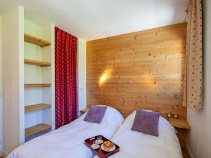 two beds in a room with a wooden wall at Apartment Le Shamrock by Interhome in Tignes